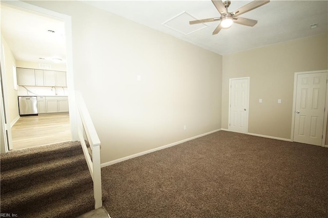 interior space featuring a sink, baseboards, a ceiling fan, and light colored carpet