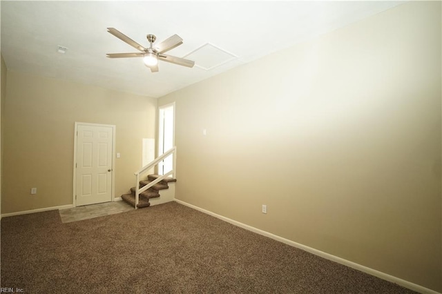 carpeted empty room featuring ceiling fan, attic access, and baseboards