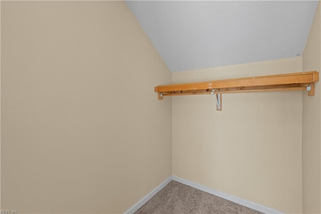 spacious closet with light carpet and vaulted ceiling