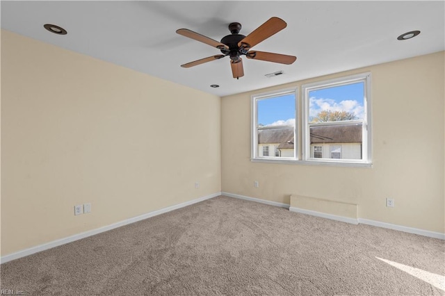 unfurnished room with ceiling fan, carpet floors, visible vents, and baseboards