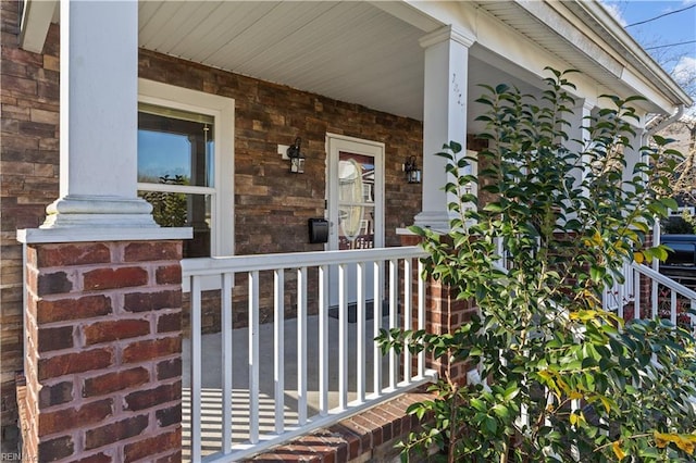 entrance to property with brick siding and a porch