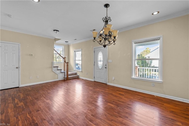 entrance foyer featuring baseboards, stairway, wood finished floors, and crown molding