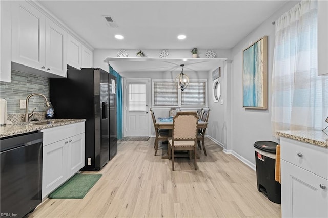 kitchen with a sink, white cabinets, light wood-style floors, decorative backsplash, and dishwasher