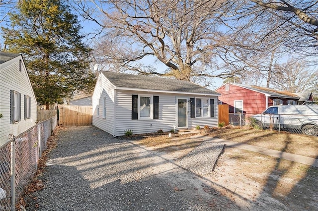 bungalow with a shingled roof and fence