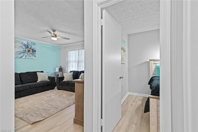 interior space featuring a textured ceiling, wood finished floors, and baseboards