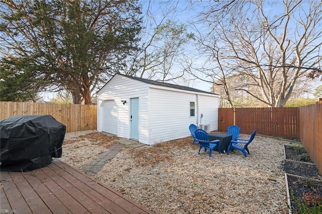 exterior space with a grill, a fire pit, a fenced backyard, and an outbuilding