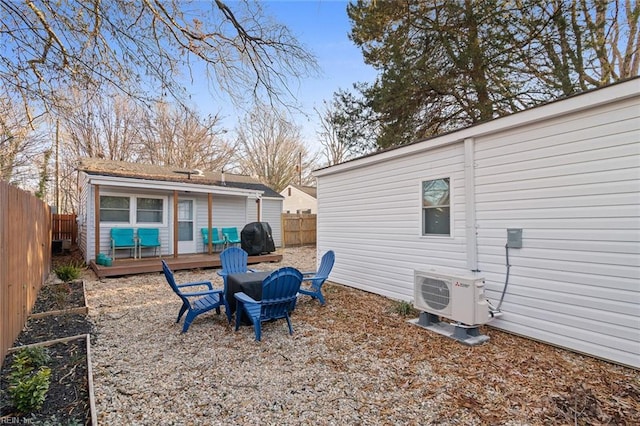 exterior space with ac unit, a fenced backyard, an outdoor fire pit, and a wooden deck