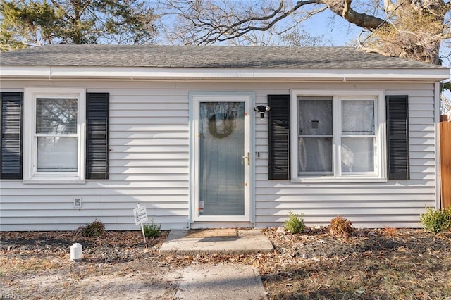 property entrance featuring roof with shingles