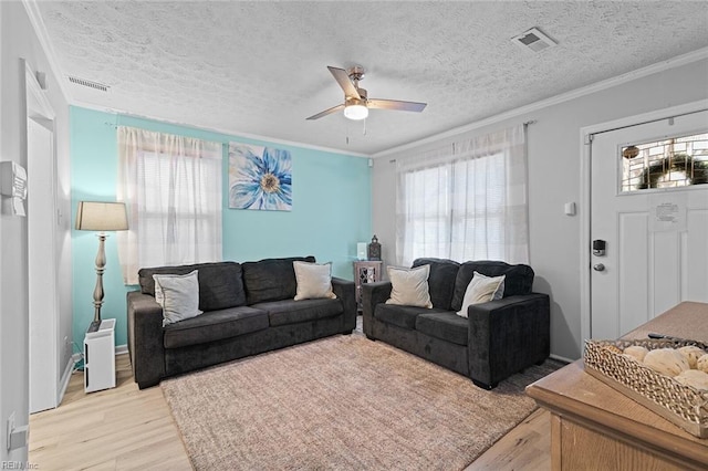 living area with a healthy amount of sunlight, light wood-style flooring, and visible vents