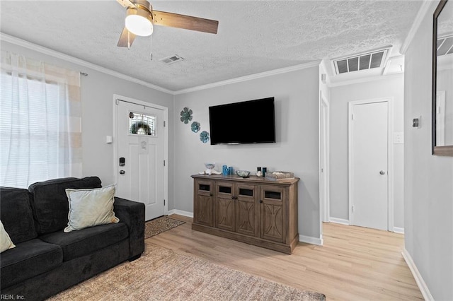 living area featuring visible vents, crown molding, a textured ceiling, and wood finished floors