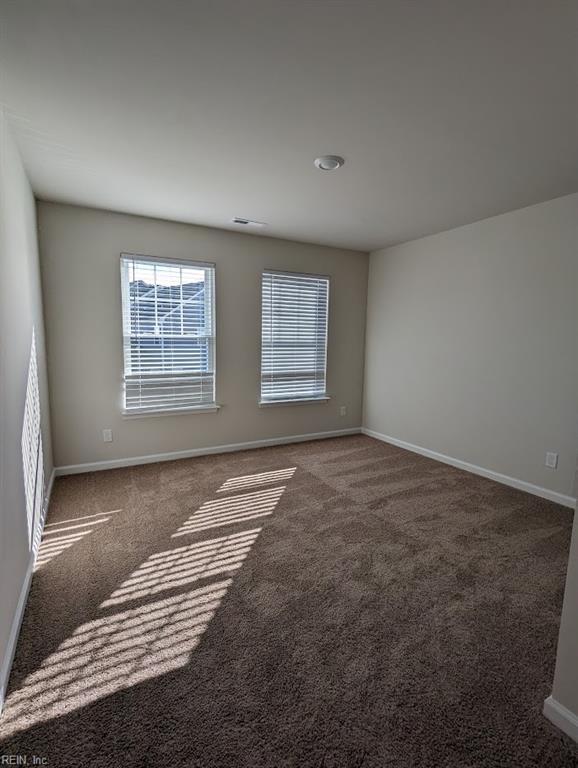 carpeted spare room featuring baseboards