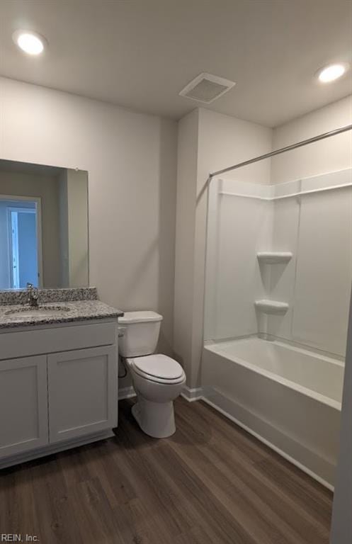 full bath with shower / bathtub combination, visible vents, toilet, vanity, and wood finished floors