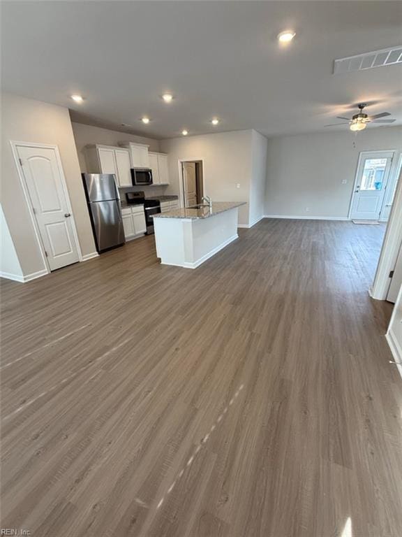 kitchen with dark wood-style flooring, visible vents, white cabinets, open floor plan, and appliances with stainless steel finishes