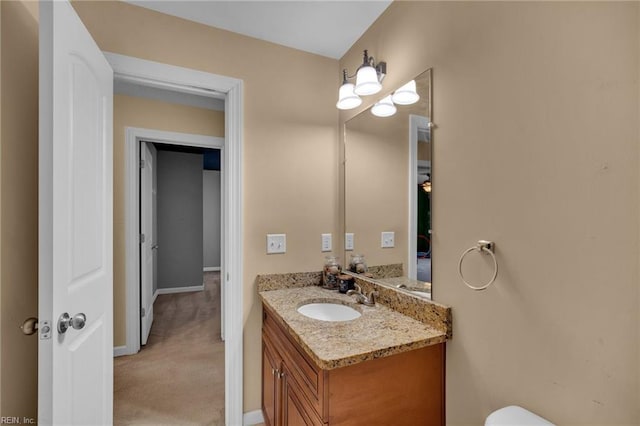 half bath with baseboards and vanity