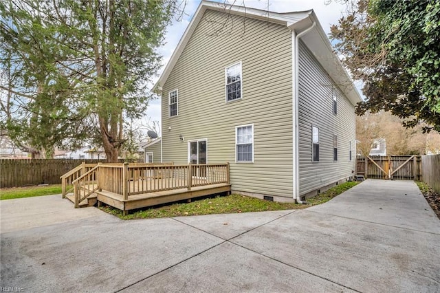 back of house with crawl space, fence, and a deck