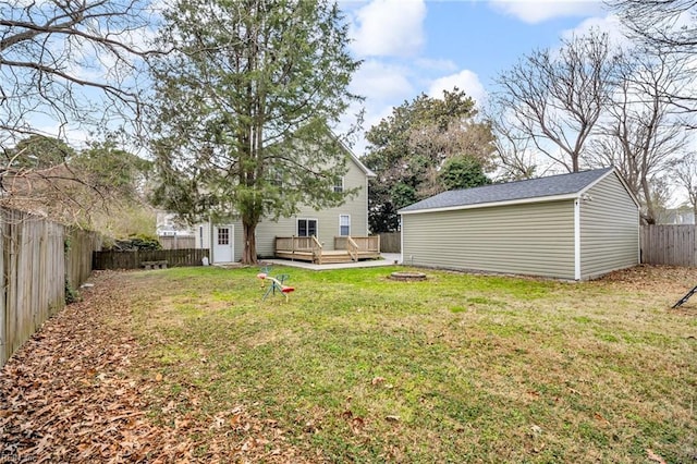 view of yard featuring an outdoor fire pit, a fenced backyard, an outdoor structure, and a wooden deck