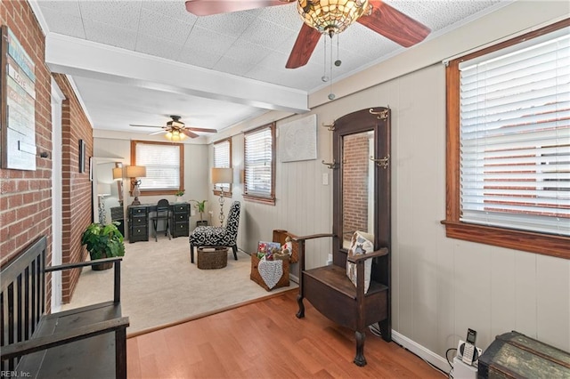 sitting room featuring crown molding, a fireplace, a ceiling fan, and wood finished floors