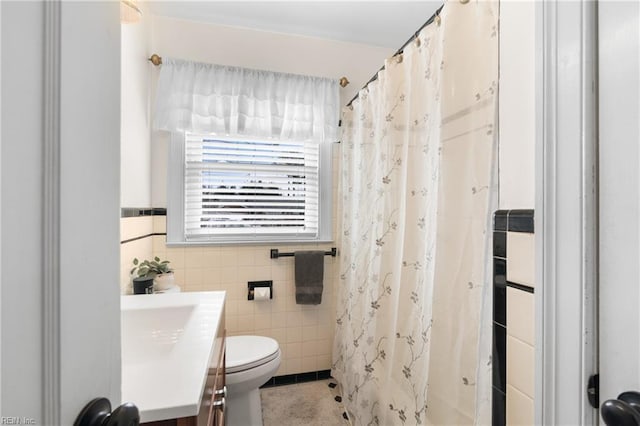 bathroom featuring toilet, a shower with curtain, tile walls, and vanity