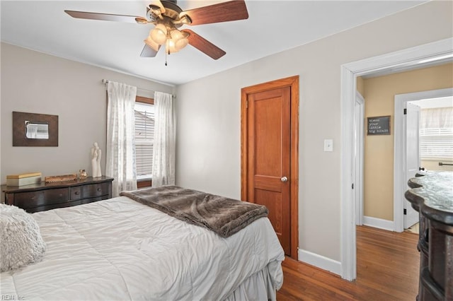 bedroom with a ceiling fan, baseboards, and wood finished floors