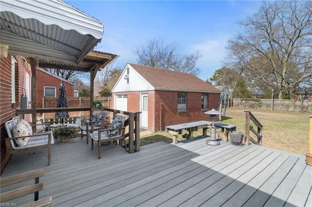 wooden terrace featuring an outbuilding, a lawn, outdoor lounge area, and a fenced backyard