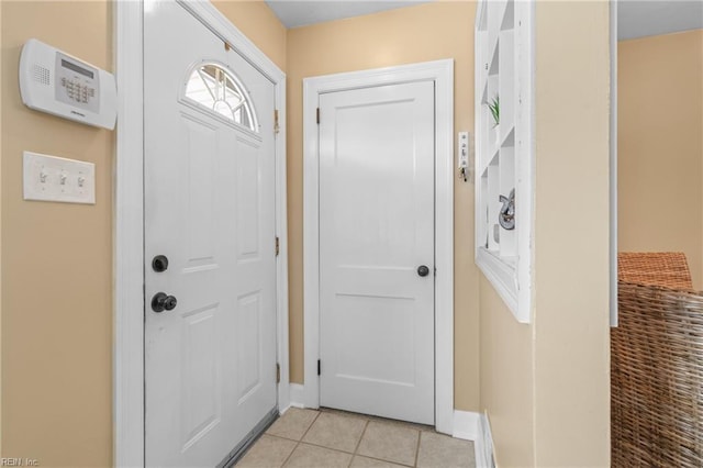 doorway with baseboards and light tile patterned floors