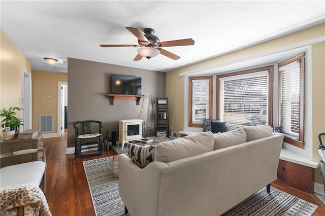 living area with ceiling fan, dark wood finished floors, visible vents, and baseboards