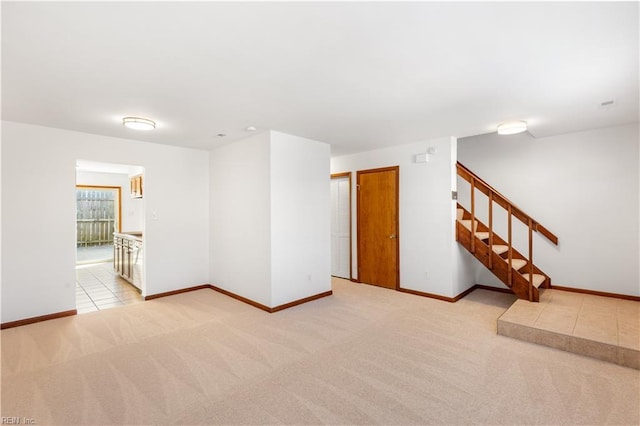 spare room featuring stairs, carpet flooring, and baseboards