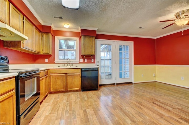 kitchen featuring light wood finished floors, light countertops, visible vents, a sink, and black appliances