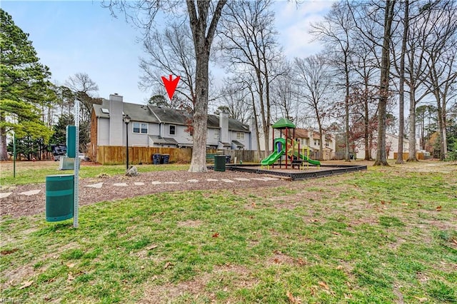 view of yard featuring playground community and fence