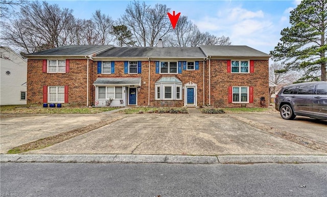 multi unit property featuring a chimney and brick siding