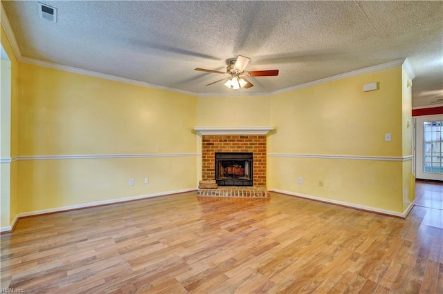 unfurnished living room featuring a fireplace, visible vents, ornamental molding, ceiling fan, and wood finished floors