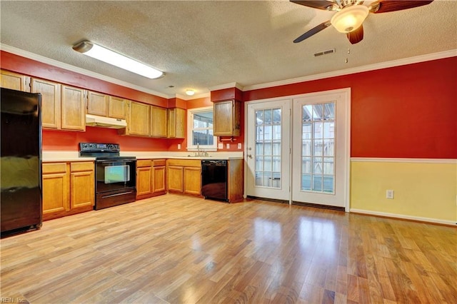 kitchen with black appliances, under cabinet range hood, light countertops, and light wood finished floors