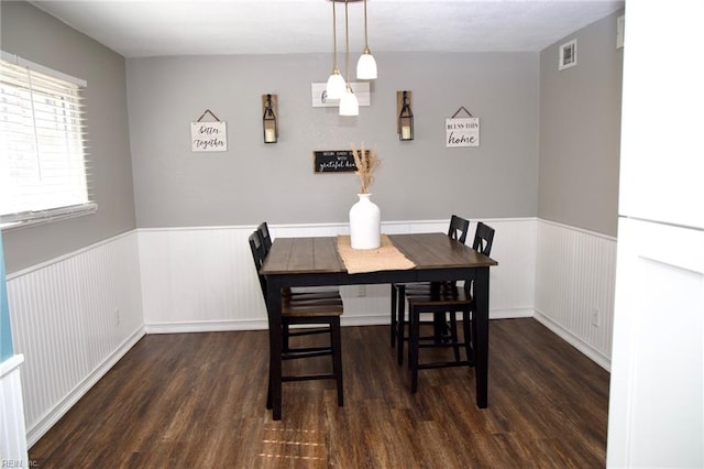 dining room featuring a wainscoted wall, dark wood-style floors, and visible vents