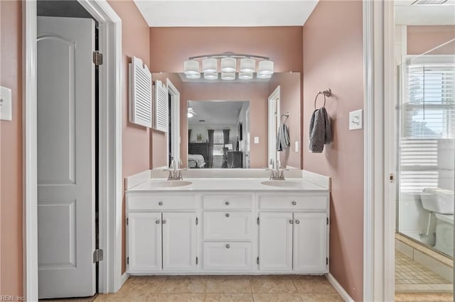 ensuite bathroom with ensuite bathroom, tile patterned flooring, a sink, double vanity, and a stall shower