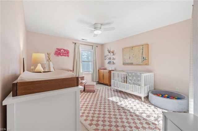 carpeted bedroom featuring visible vents and a ceiling fan