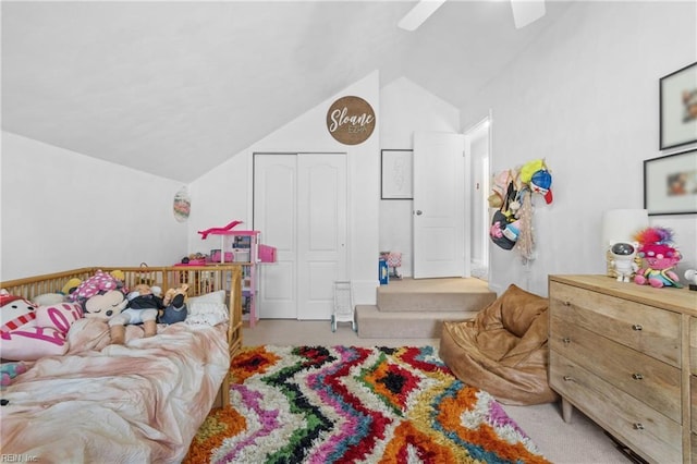 bedroom with lofted ceiling, a closet, carpet, and a ceiling fan