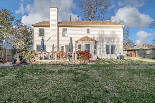 back of property featuring a fenced backyard, a chimney, and a yard