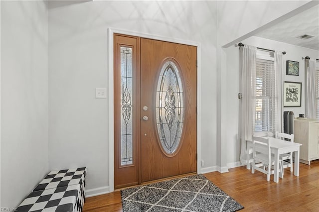 foyer featuring wood finished floors, visible vents, and baseboards