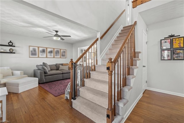 stairs with a ceiling fan, baseboards, and wood finished floors