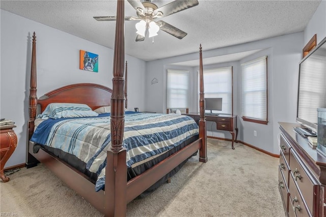 bedroom with light carpet, ceiling fan, baseboards, and a textured ceiling