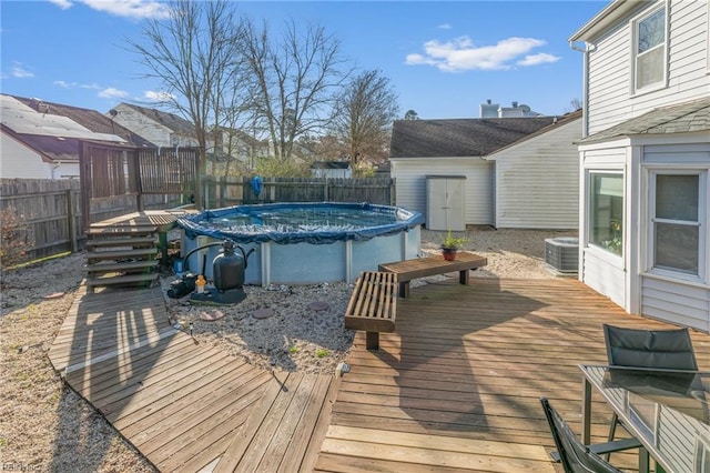 wooden deck featuring a fenced in pool, cooling unit, and a fenced backyard