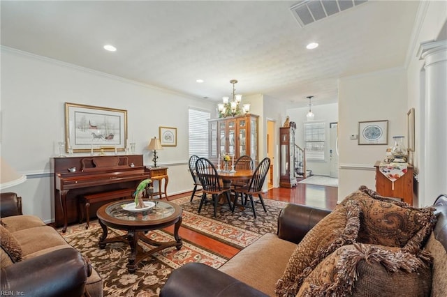 living room featuring wood finished floors, visible vents, and crown molding