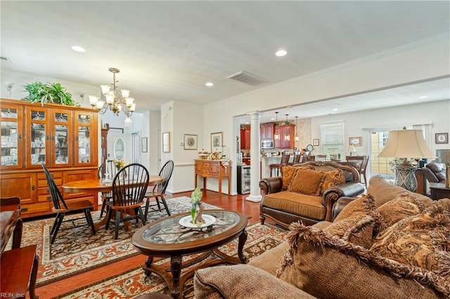 living area with crown molding, a chandelier, wood finished floors, and recessed lighting