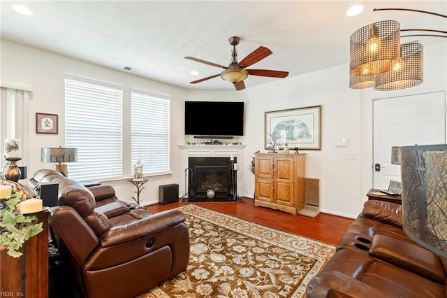 living area featuring recessed lighting, a fireplace with flush hearth, visible vents, a ceiling fan, and dark wood finished floors