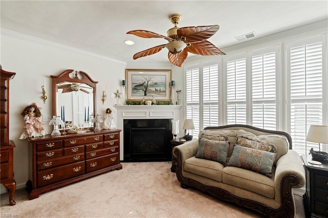 living room with a fireplace, light colored carpet, visible vents, ornamental molding, and a ceiling fan