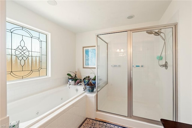 bathroom featuring a whirlpool tub and a shower stall