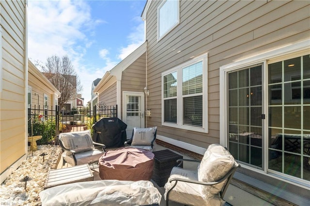 view of patio with a grill, fence, and outdoor lounge area