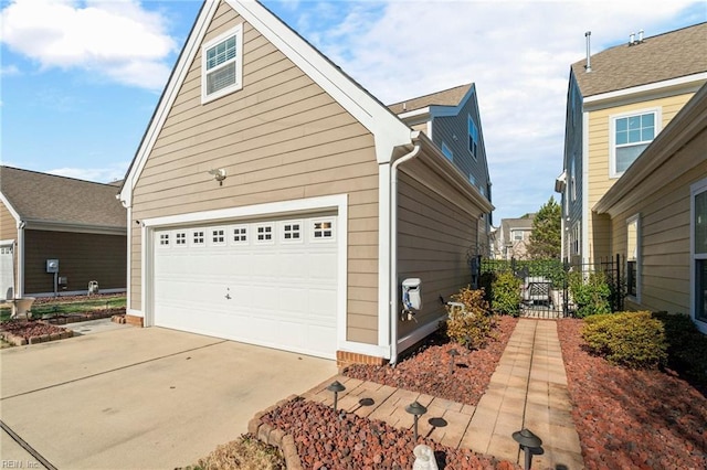 view of home's exterior with a garage and fence