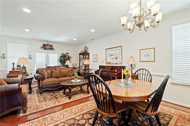 dining area with ornamental molding, recessed lighting, an inviting chandelier, and wood finished floors