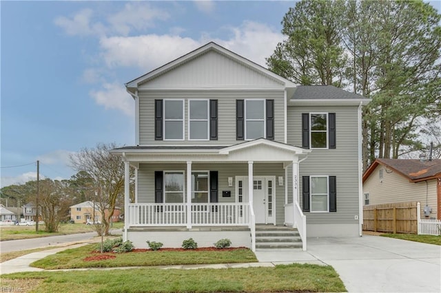 view of front of house with concrete driveway, a porch, and fence